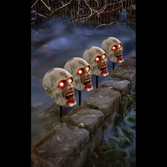 4 Zombie Head Pathway Markers with glowing orange eyes and a misty fog background