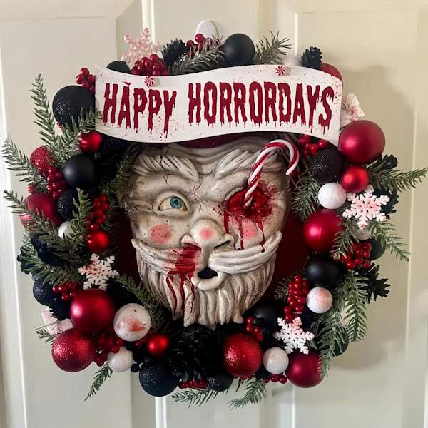 Bloody Santa Christmas Holiday wreath. A wreath with a banner reading "Happy Horrordays". A santa head with the left eye impaled with a candy cane sits in the middle of the decoration. Blood dripping from the candy cane and random blood spatters complete the look