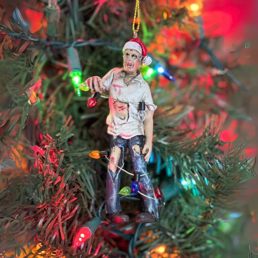 A zombie Christmas Tree ornament: A zombie wearing a santa hat wrapped up in Christmas light strand